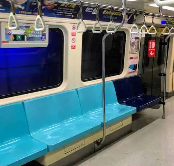 A close-up of a Taipei MRT subway train seat, with a blue design and a silver hand grip above.