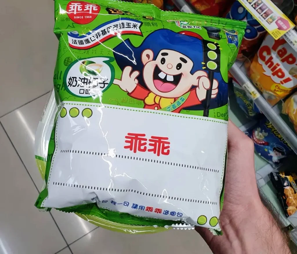 person holding a green bag of kuai kuai, taiwanese snacks
